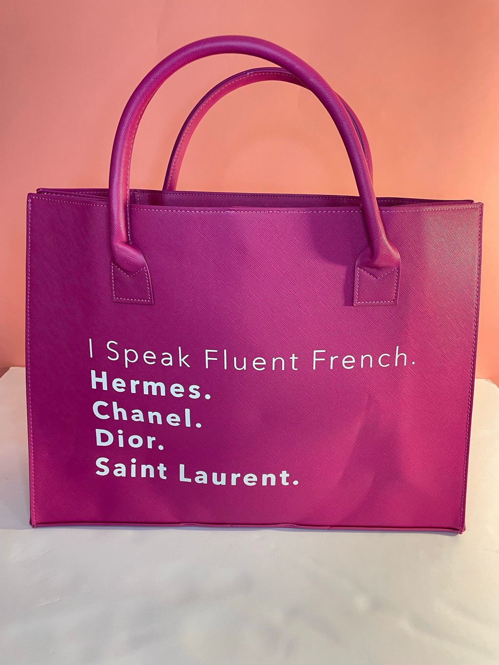 It's BAG season! And we have the must have bags of the season! Shop our 100% vegan leather "I Speak Fluent French Designers" magenta tote! A beautiful timeless piece to add to your wardrobe collection! This Luxurious vegan leather Black tote is the must have handbag of the season. Very spacious.